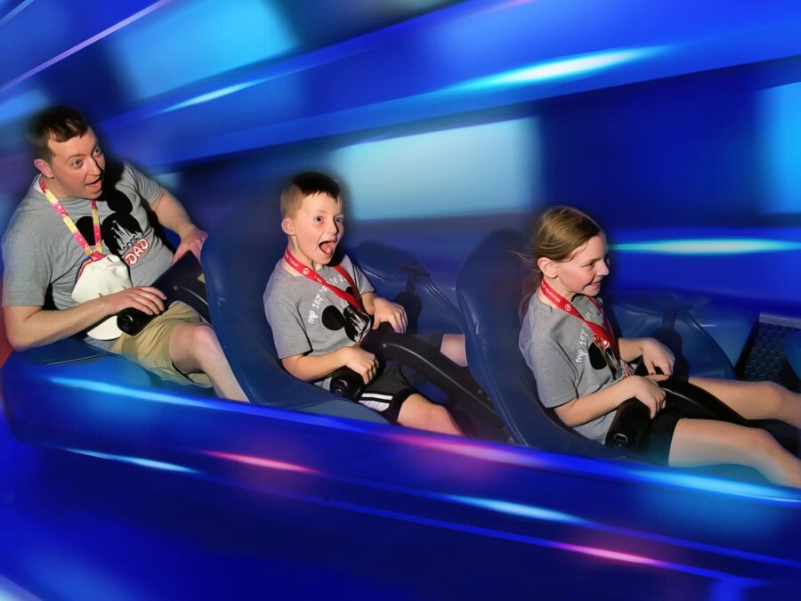 man and 2 children on Disney World ride
